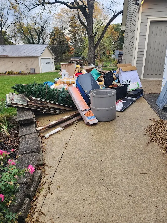 Dumpster being loaded with debris for Estate Cleanout Dumpster Rental in Fort Leonard Wood